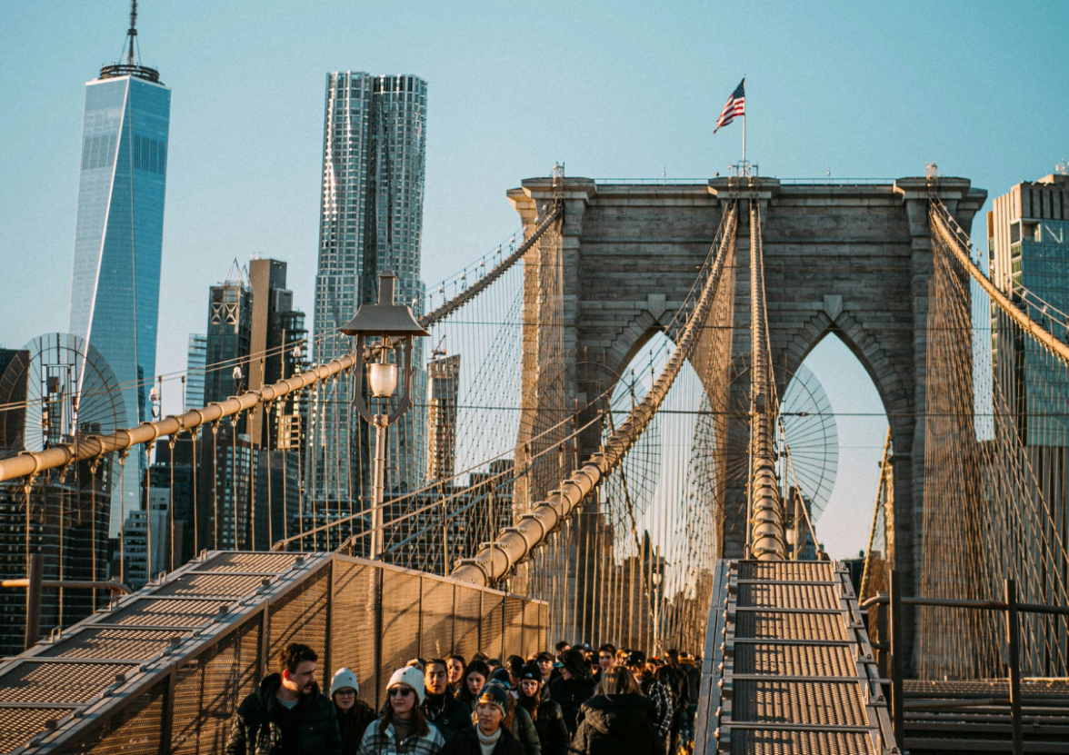 A group of people walking across Brooklyn Bridge in Brooklyn, New York.