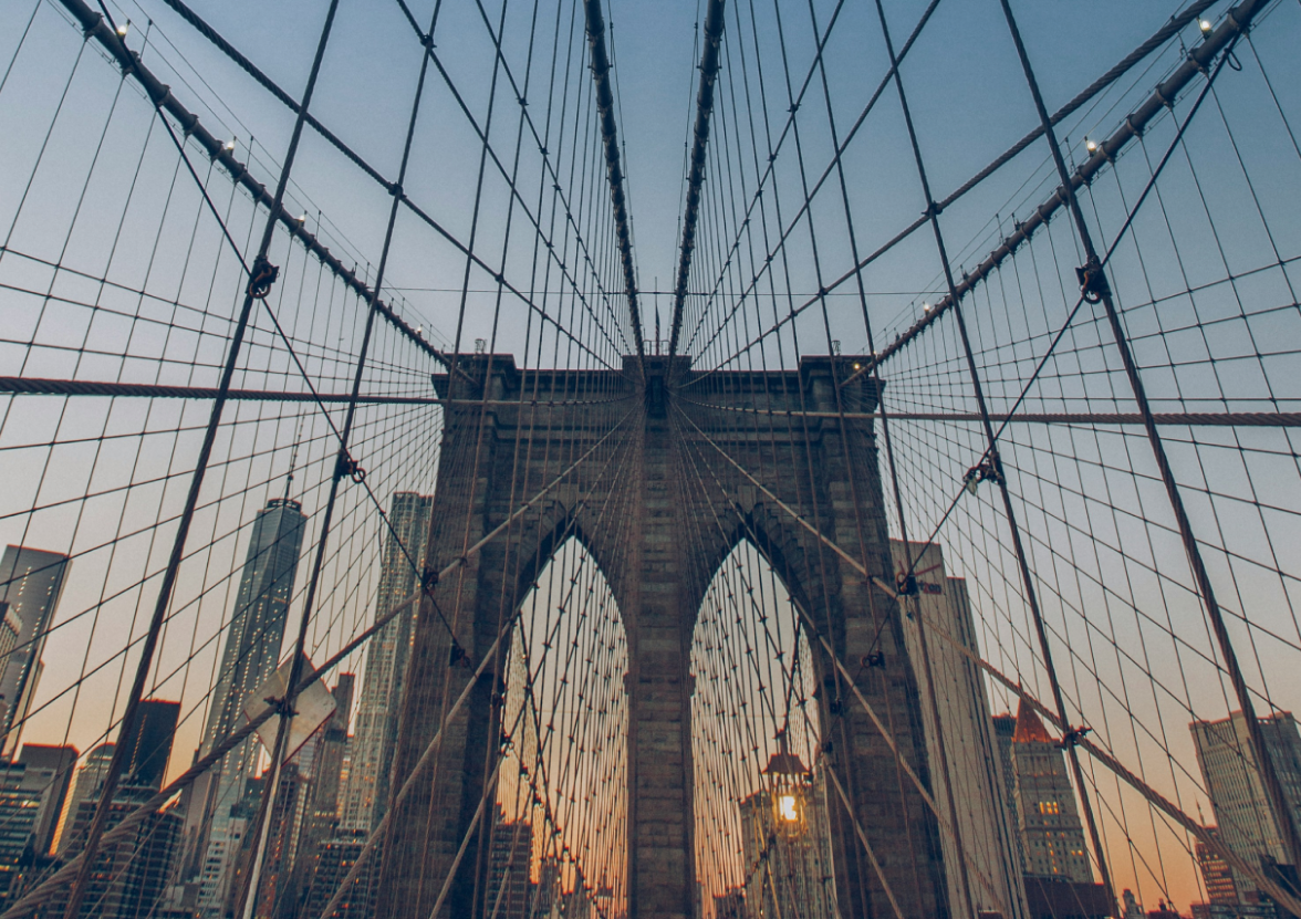 Cables of the Brooklyn Bridge at sunset, creating a geometric pattern across the sky.
